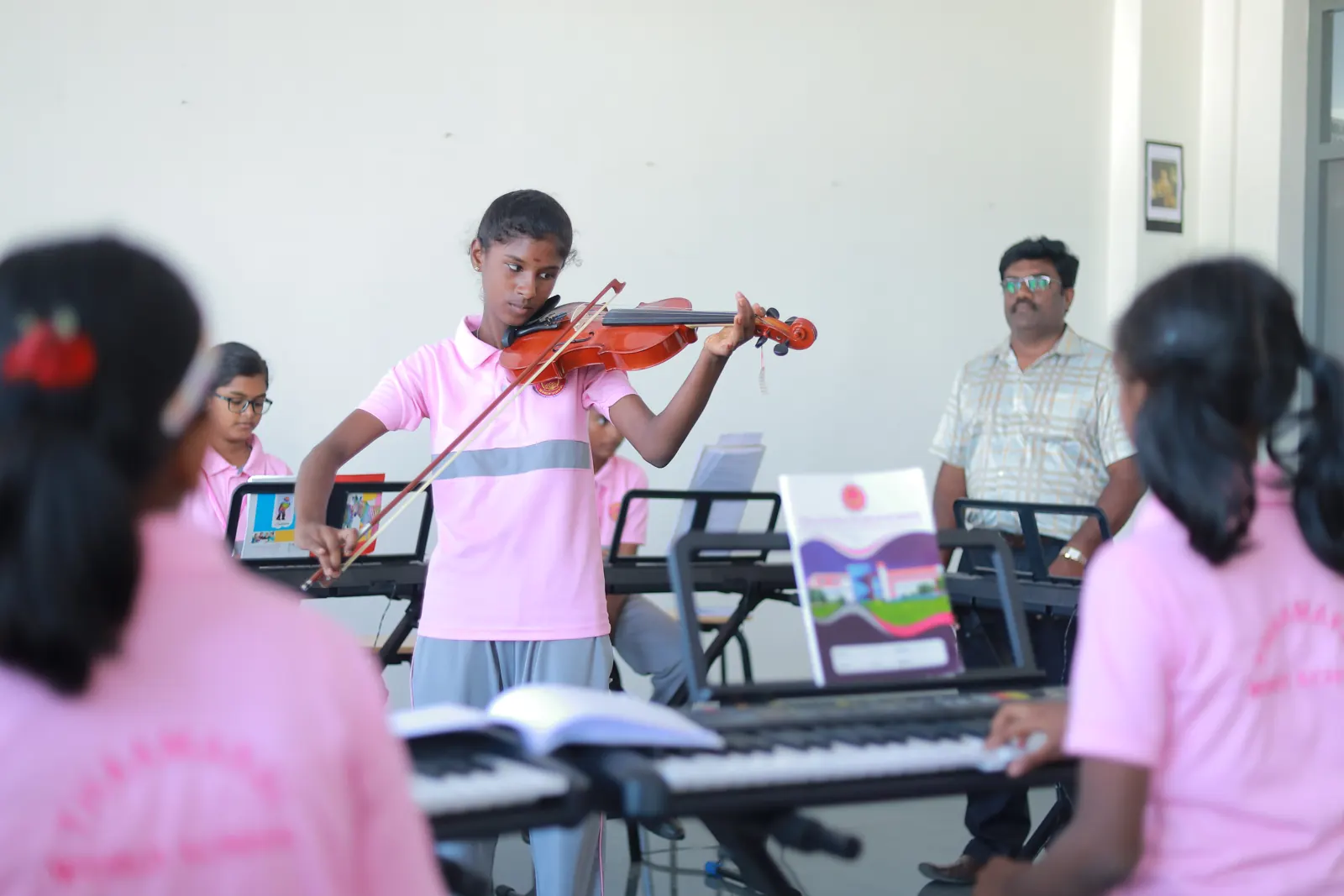 A girl plays the violin in the music room