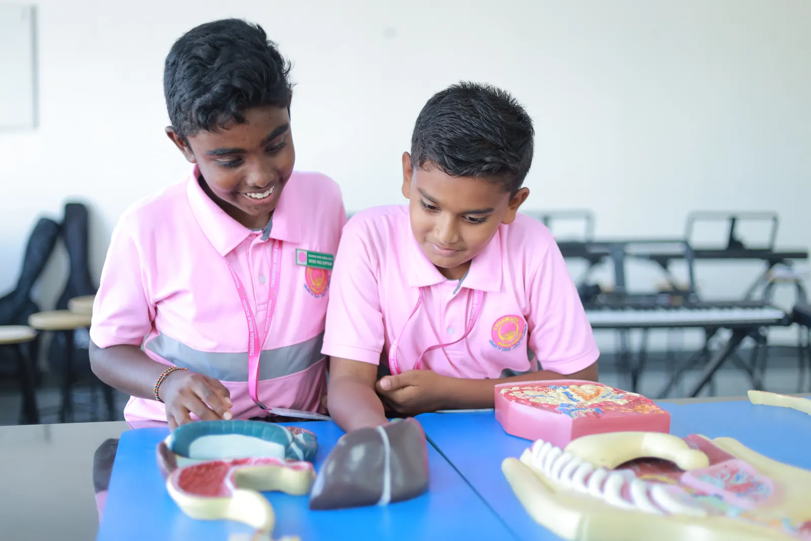 Two boys examine an anatomy model of the human body