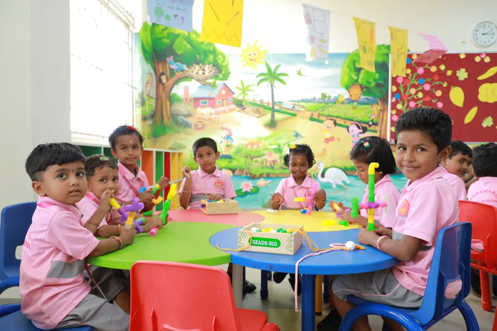 Young children work together at a round table in a brightly painted classroom