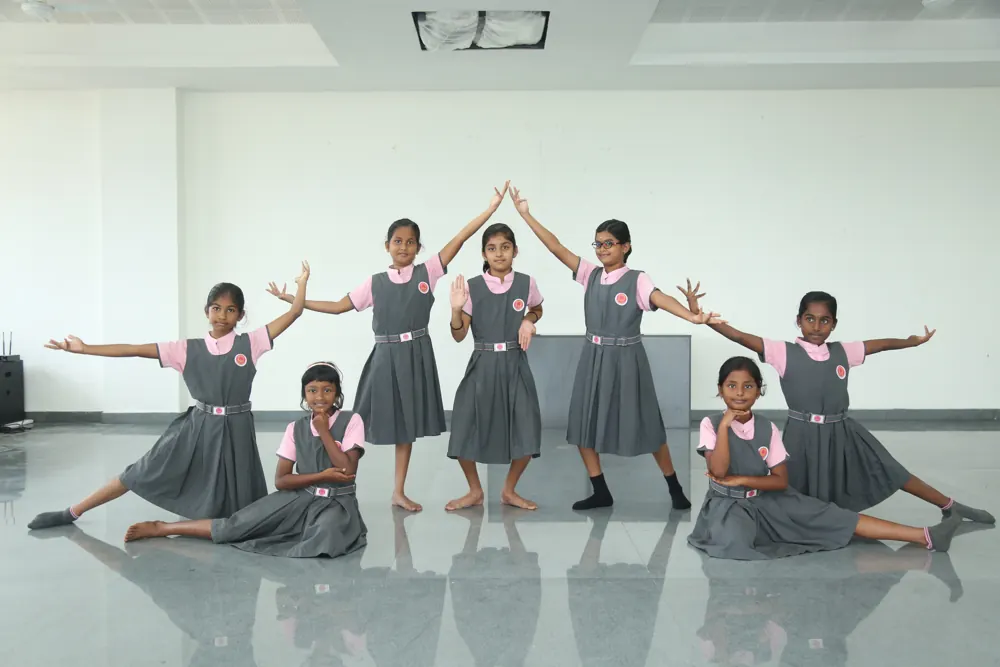 Girls hold a dance pose together in the hall