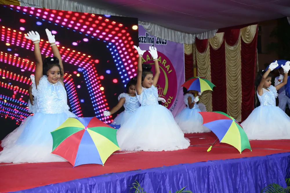 Young girls in white dresses dance with bright umbrellas on stage