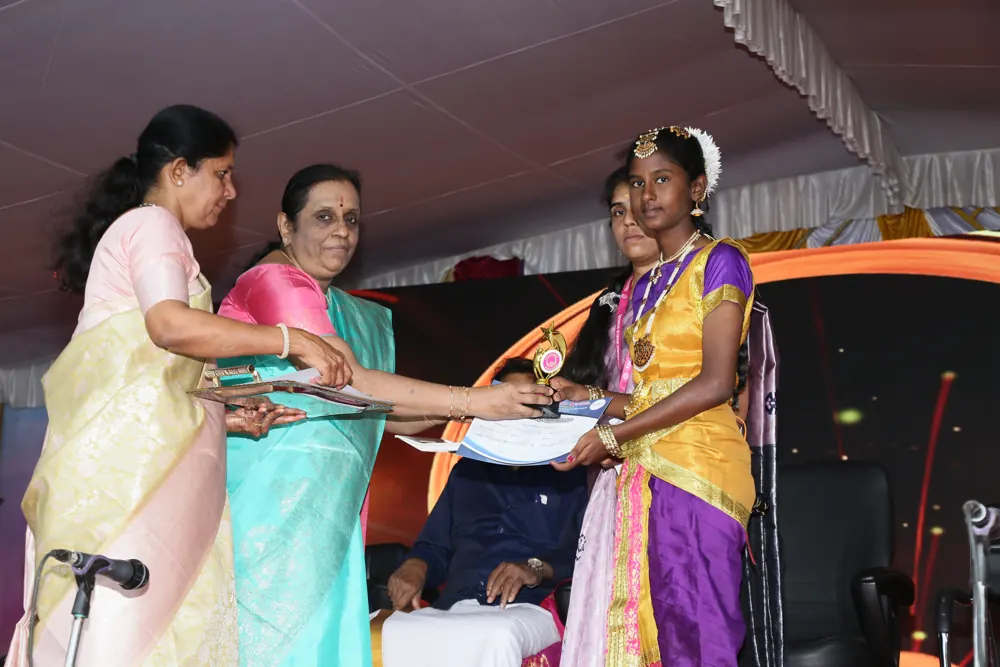 A student in dance costume receives a prize on stage