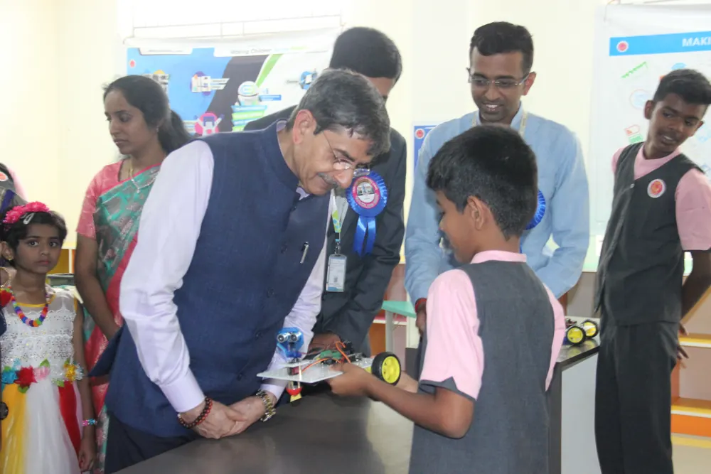 A boy shows his model to a visiting guest