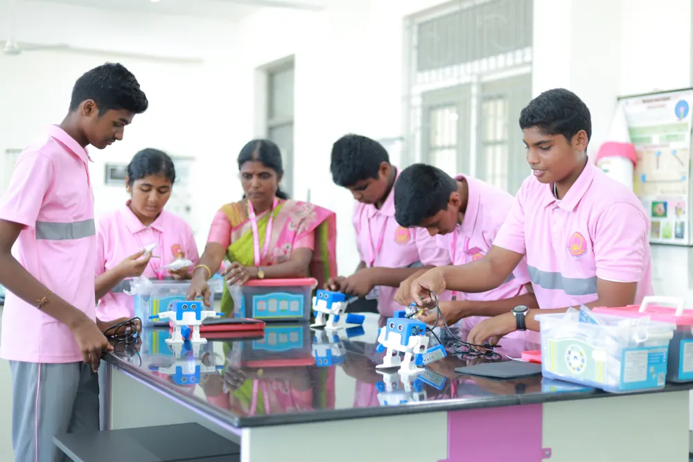 Students and their teacher build an experiment together at a lab bench